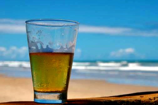 Baytowne Wharf Beer Fest glass of beer on the beach with the Gulf in the background