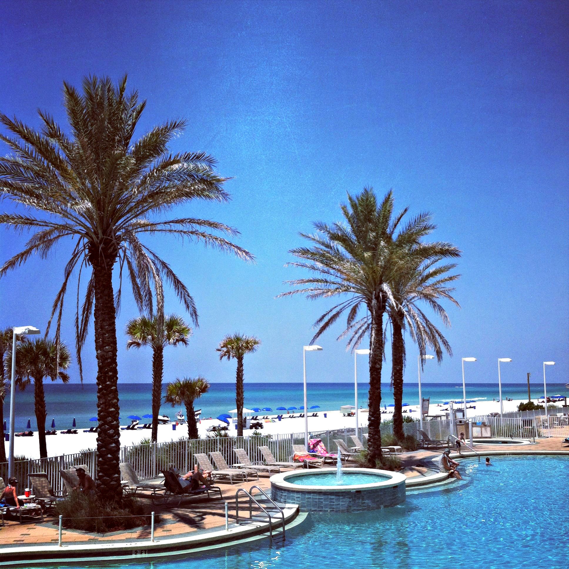 Palm trees and attractive landscaping frame the Gulf-front pool at Boardwalk Beach Resort in Panama City Beach.