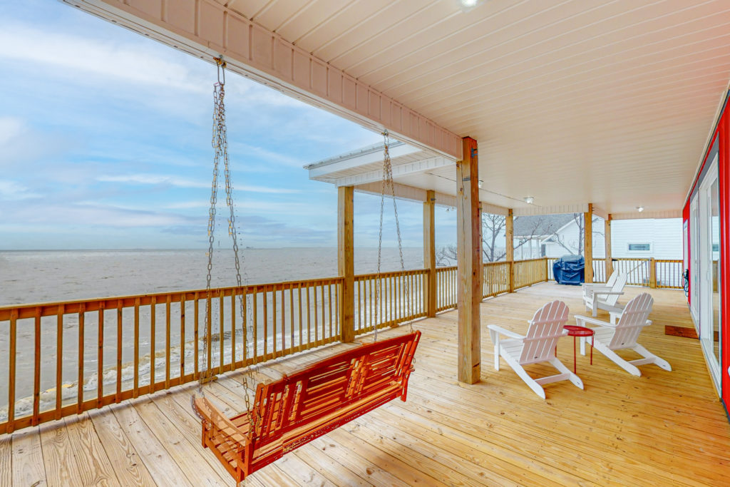 The furnished deck of Sea of Love beach house looking out over the water in Dauphin Island, Alabama.