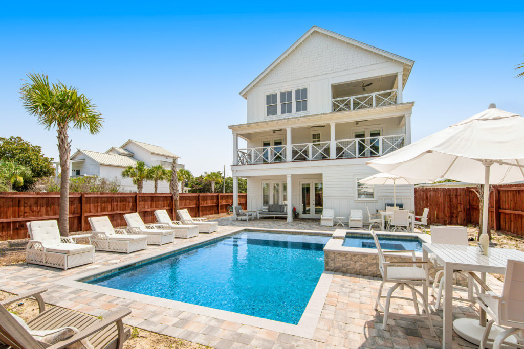 Exterior, fenced-in yard, and swimming pool of Waterdog 1 house near the beach in Destin, Florida.
